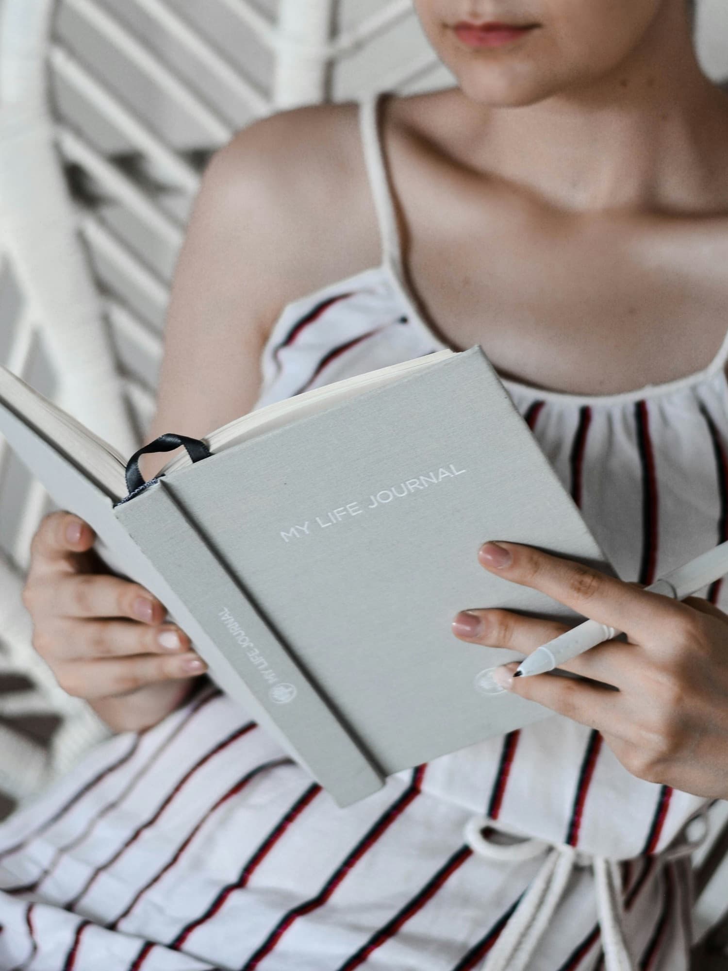 Hands holding an open journal and a pen